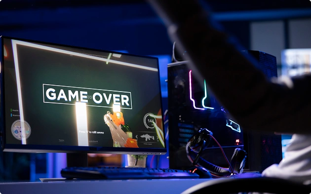 A játékos csalódottan eldobja a fejhallgatóját a vereség után; a képernyőn megjelenik a „Game Over” felirat.