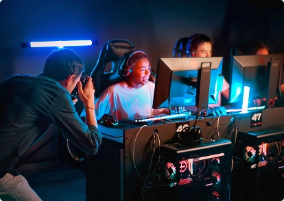 Egy fotós egy e-sport-bajnokságon a számítógépük előtt ülő játékosokat fényképez.