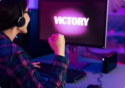 Egy női játékos ünnepli győzelmét; a képernyőn a „Victory” felirat látható.